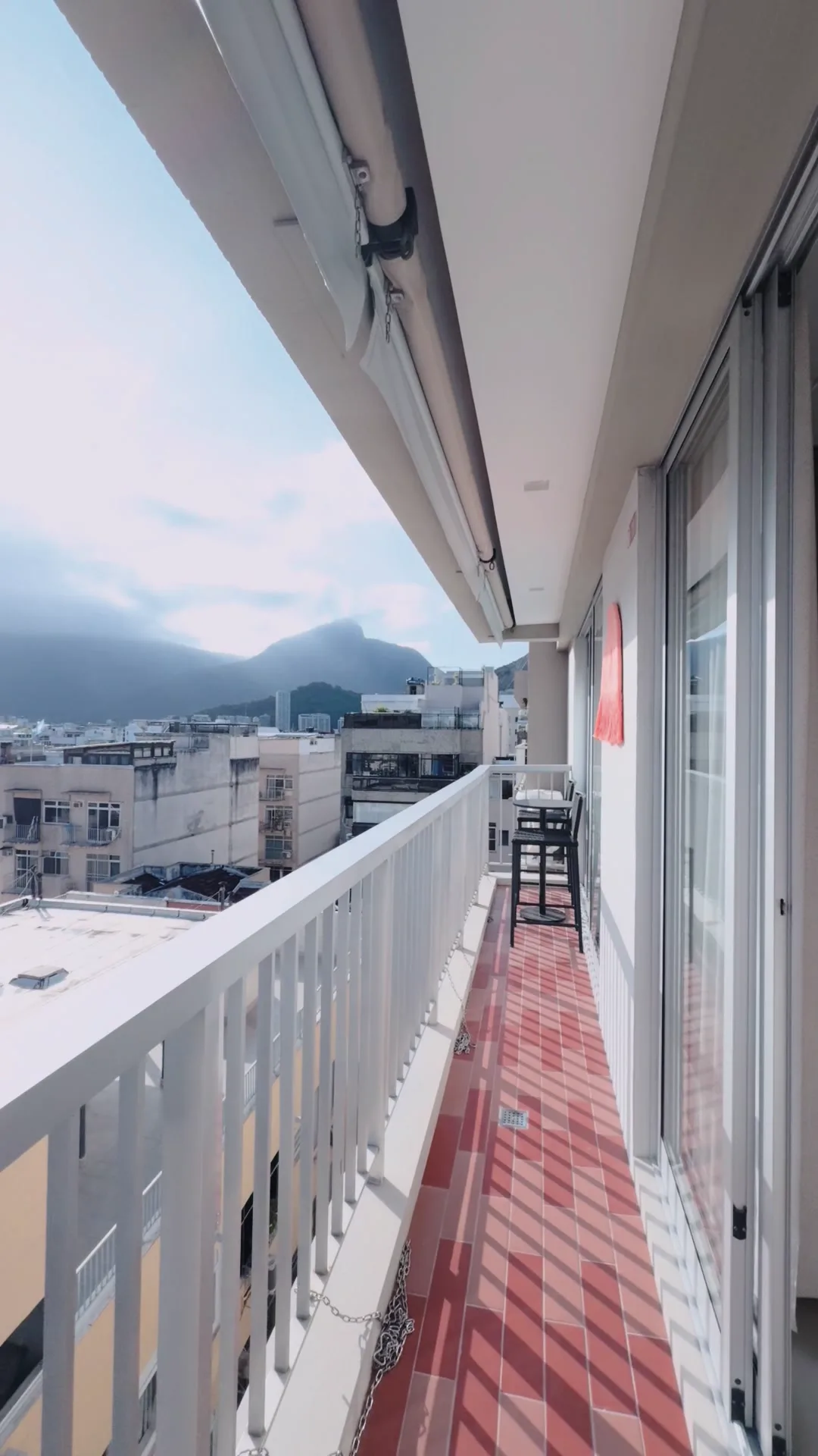 Varanda do apartamento da Voyage Villas em Ipanema, com o bairro e a serra ao fundo