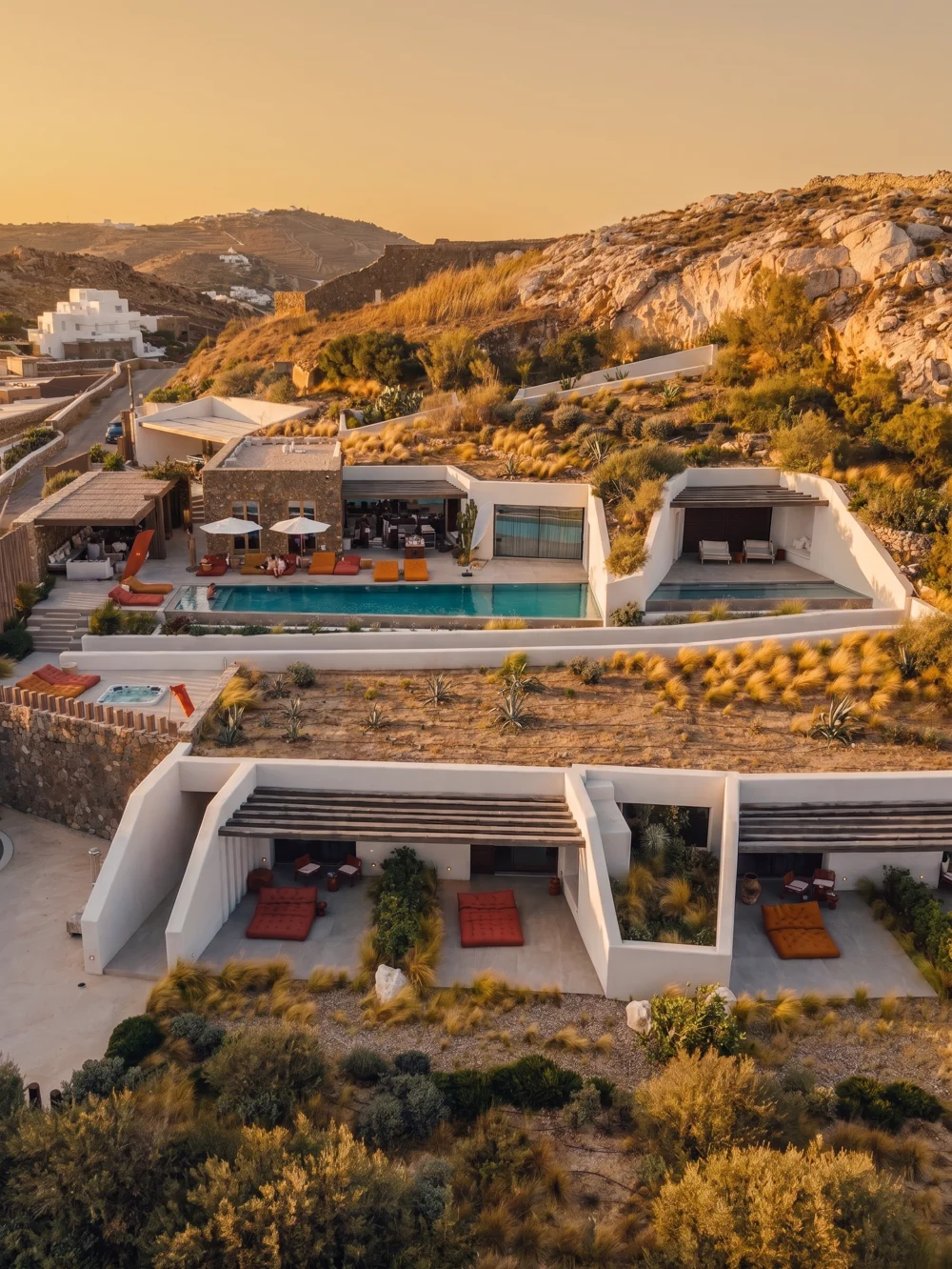 Vista aérea da Voyage Villas Mykonos ao fim da tarde, com piscina e terraços